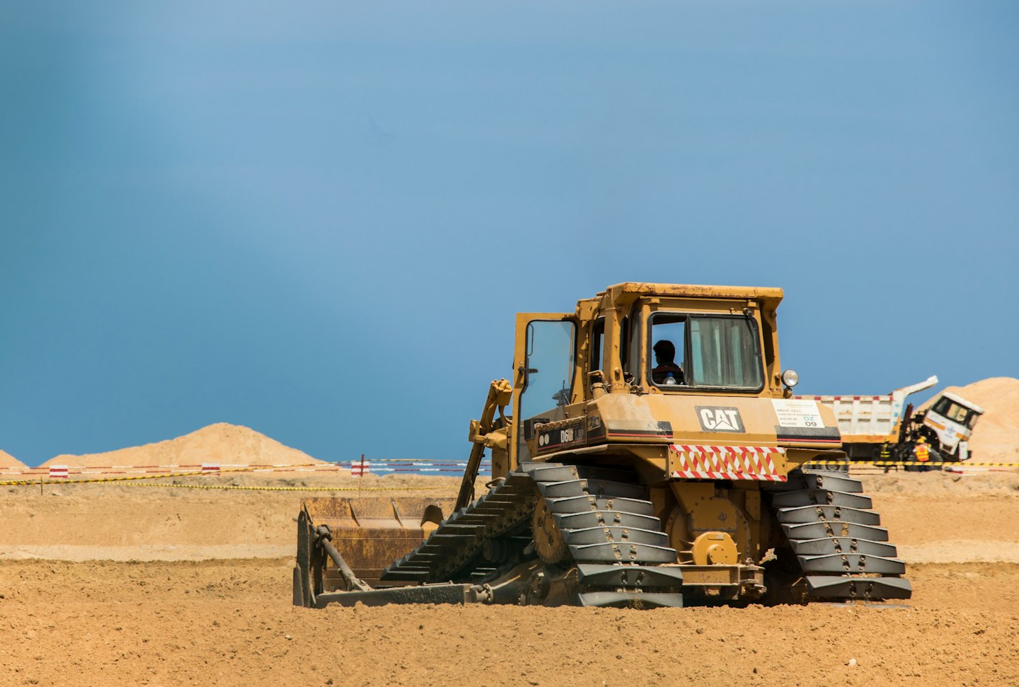 A yellow bulldozer moves dirt on a construction site.
